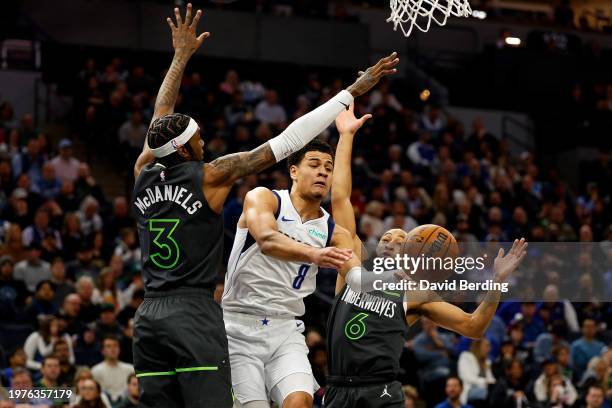 Josh Green of the Dallas Mavericks passes the ball while Jaden McDaniels and Jordan McLaughlin of the Minnesota Timberwolves defend in the second...