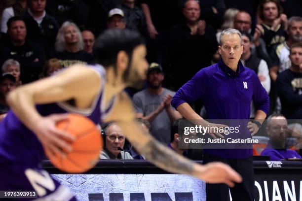 Head coach Chris Collins of the Northwestern Wildcats watches Boo Buie of the Northwestern Wildcats bring the ball up court in overtime against the...