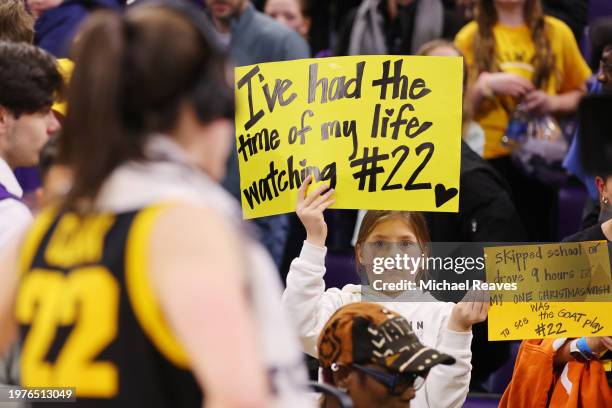 Young fan holds a sign as Caitlin Clark of the Iowa Hawkeyes is interviewed after the game against the Northwestern Wildcats at Welsh-Ryan Arena on...