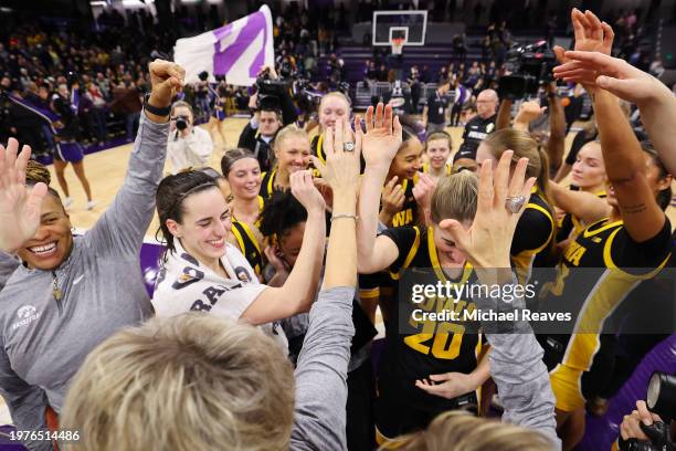 Caitlin Clark of the Iowa Hawkeyes celebrates with teammates after defeating the Northwestern Wildcats at Welsh-Ryan Arena on January 31, 2024 in...