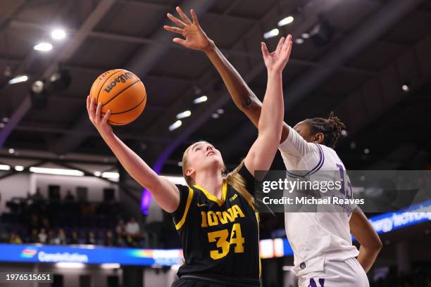 Ediger of the Iowa Hawkeyes shoots over Mercy Ademusayo of the Northwestern Wildcats during the second half at Welsh-Ryan Arena on January 31, 2024...