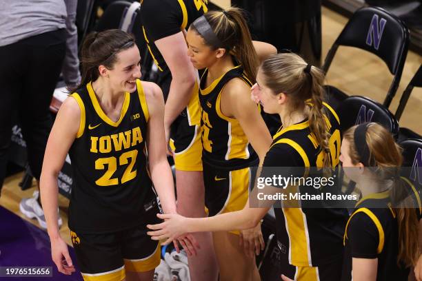 Caitlin Clark of the Iowa Hawkeyes high fives teammates against the Northwestern Wildcats during the second half at Welsh-Ryan Arena on January 31,...