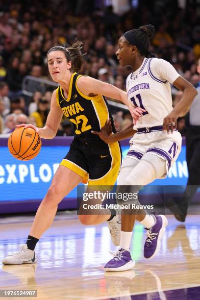 Caitlin Clark of the Iowa Hawkeyes drives to the basket against Hailey Weaver of the Northwestern Wildcats during the first half at Welsh-Ryan Arena...