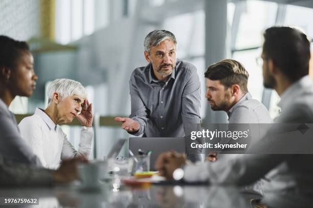 male ceo talking to his team on a meeting in the office. - negatief praten stockfoto's en -beelden