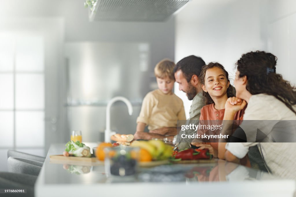 Family cooperating while making a meal in the kitchen.
