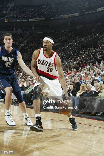 Rasheed Wallace of the Portland Trail Blazers drives around Raef LaFrentz of the Dallas Mavericks in Game four of the Western Conference...