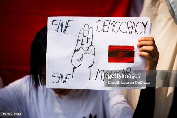 Myanmar people hold up a sign that reads "save democracy, save Myanmar" during a gathering at the United Nations on February 01, 2024 in Bangkok,...