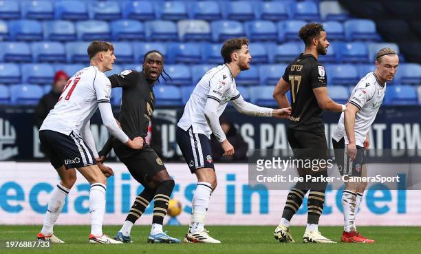 Barnsley's Devante Cole reacts to Bolton Wanderers' Caleb Taylor grabbing his shirt with Jack Iredale and Kyle Dempsey and Barnsley's Barry Cotter...