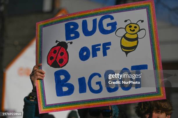 An activist holds a poster as hundreds of activists, allies, and members of the transgender community gather at Dr. Wilbert McIntyre Park in Old...