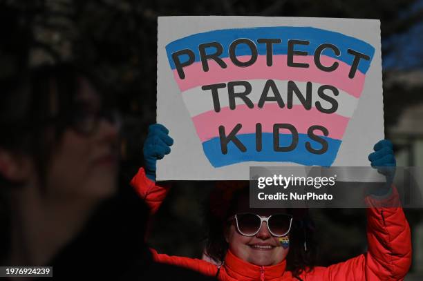 An activist holds a poster as hundreds of activists, allies, and members of the transgender community gather at Dr. Wilbert McIntyre Park in Old...