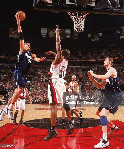 Dirk Nowitzki of the Dallas Mavericks contests the defense of Dale Davis of the Portland Trail Blazers in Game Four of the Western Conference...