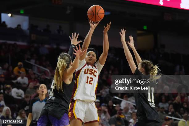 Southern California Trojans guard JuJu Watkins shoots the ball against Washington Huskies guard Teagan Brown and guard Chloe Briggs during an NCAA...