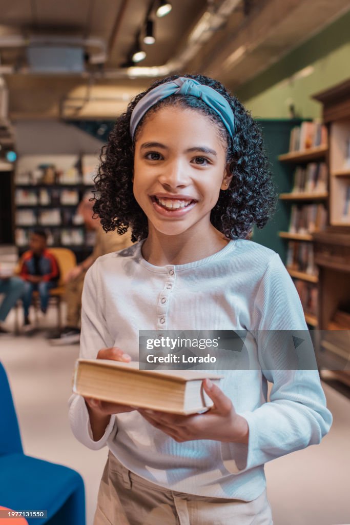 Portrait of a diverse young female school child reader in a library