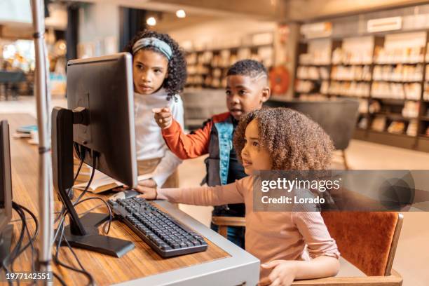 three young diverse readers using a computer in a dutch library - digital library stock pictures, royalty-free photos & images