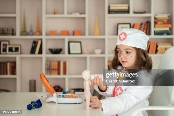 girl dressed as a doctor investigating the human body - vestita da dottoressa foto e immagini stock