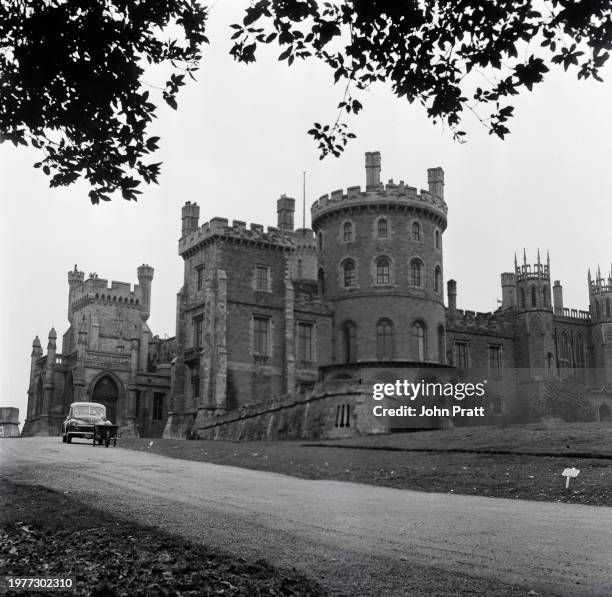 Car and wheelbarrow on the road outside Belvoir Castle, a castle and stately home, the seat of the Manners family, in northeast Leicestershire,...