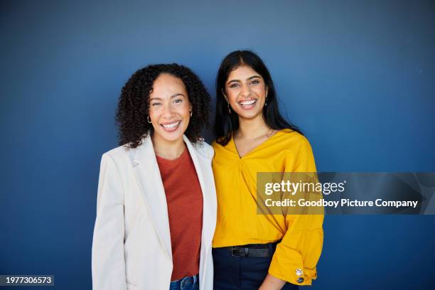 two diverse businesswomen standing in an office and laughing together - side by side stock pictures, royalty-free photos & images