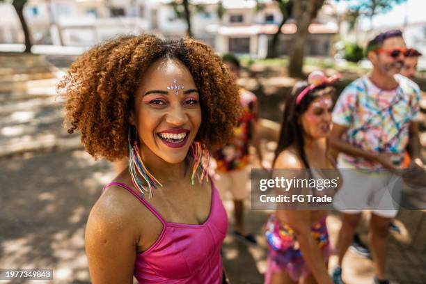 retrato de una mujer joven que disfruta de la fiesta de carnaval con amigos en el parque público - carnaval evento de celebración fotografías e imágenes de stock