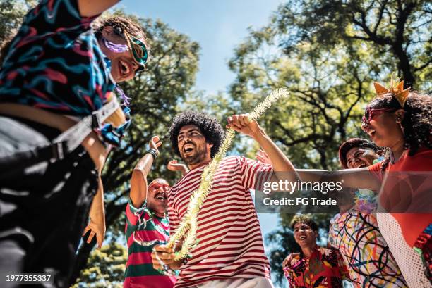 amigos celebrando fiesta de carnaval en el parque público - música latinoamericana fotografías e imágenes de stock