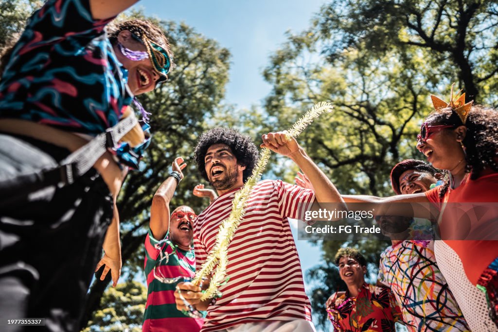 Friends celebrating carnival party on the public park