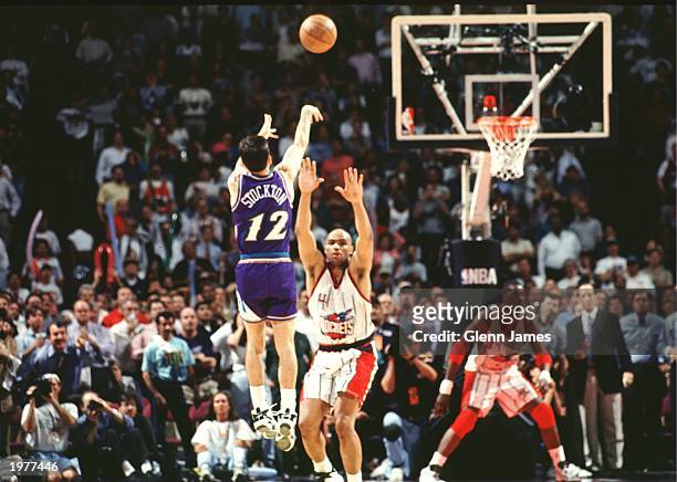 John Stockton of the Utah Jazz shoots the game winning shot over Charles Barkley of the Houston Rockets in Game six of the Western Conference...