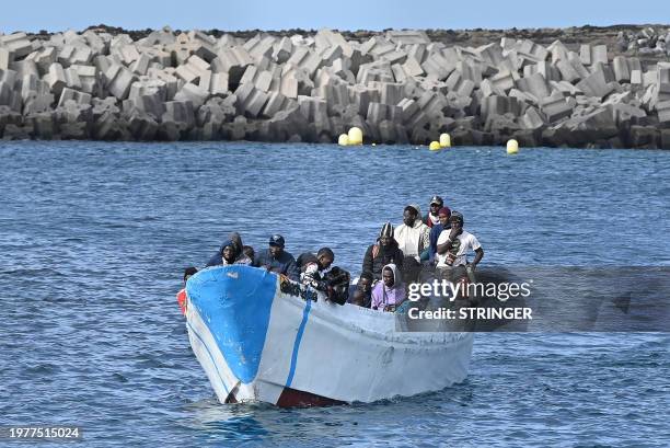 Migrants sit in a boat, after the Spanish Salvamento Maritimo vessel "Salvamar Adhara" rescued around 250 migrants in three different boats at sea,...