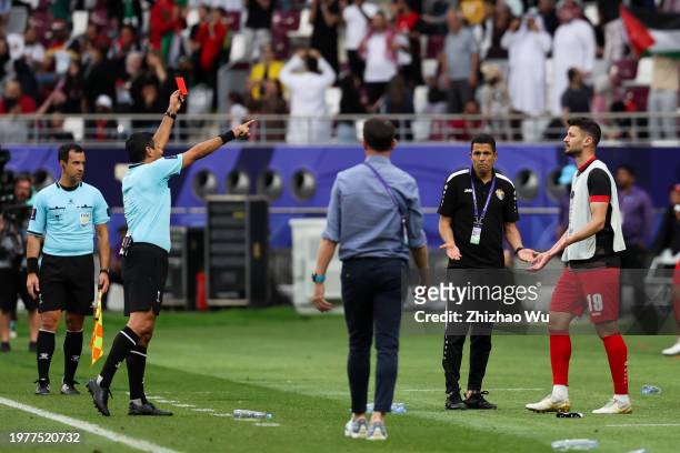 Referee Alireza Faghani gives a red card to Anas Bani-Yaseen of Jordan during the AFC Asian Cup Round of 16 match between Iraq and Jordan at Khalifa...