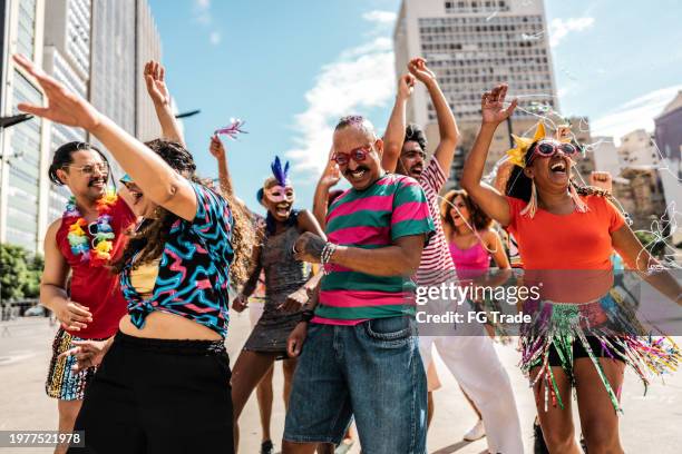 group of people having fun at a street carnival party - carnival celebration event stock-fotos und bilder