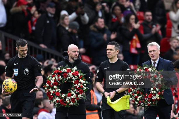 West Ham United's Scottish manager David Moyes and Manchester United's Dutch manager Erik ten Hag carry a wreath of flowers during a memorial...