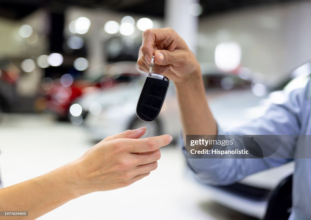 Close-up on a customer receiving the keys of their new car