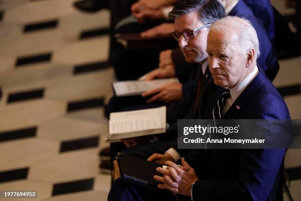 Speaker of the House Mike Johnson and U.S. President Joe Biden listen during the annual National Prayer Breakfast in Statuary Hall in the U.S....