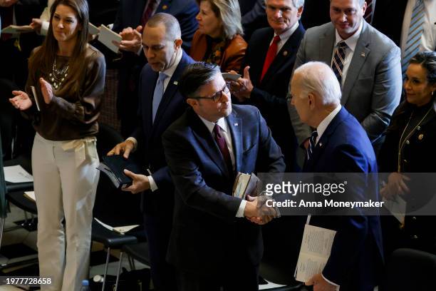 Speaker of the House Mike Johnson shakes hands with U.S. President Joe Biden during the annual National Prayer Breakfast in Statuary Hall in the U.S....