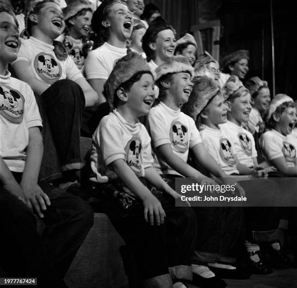 An audience of children wearing Davy Crockett-style racoon-skin caps and Mickey Mouse Club t-shirts as they laugh during the recording of 'The Mickey...