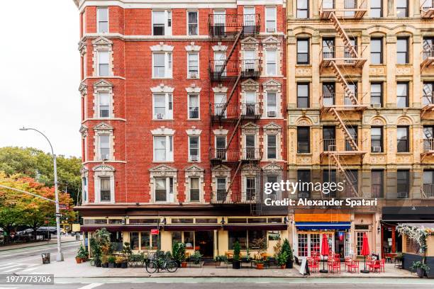 street with apartment buildings, shops and cafes in greenwich village, new york city, usa - new york city exteriors and landmarks stock pictures, royalty-free photos & images