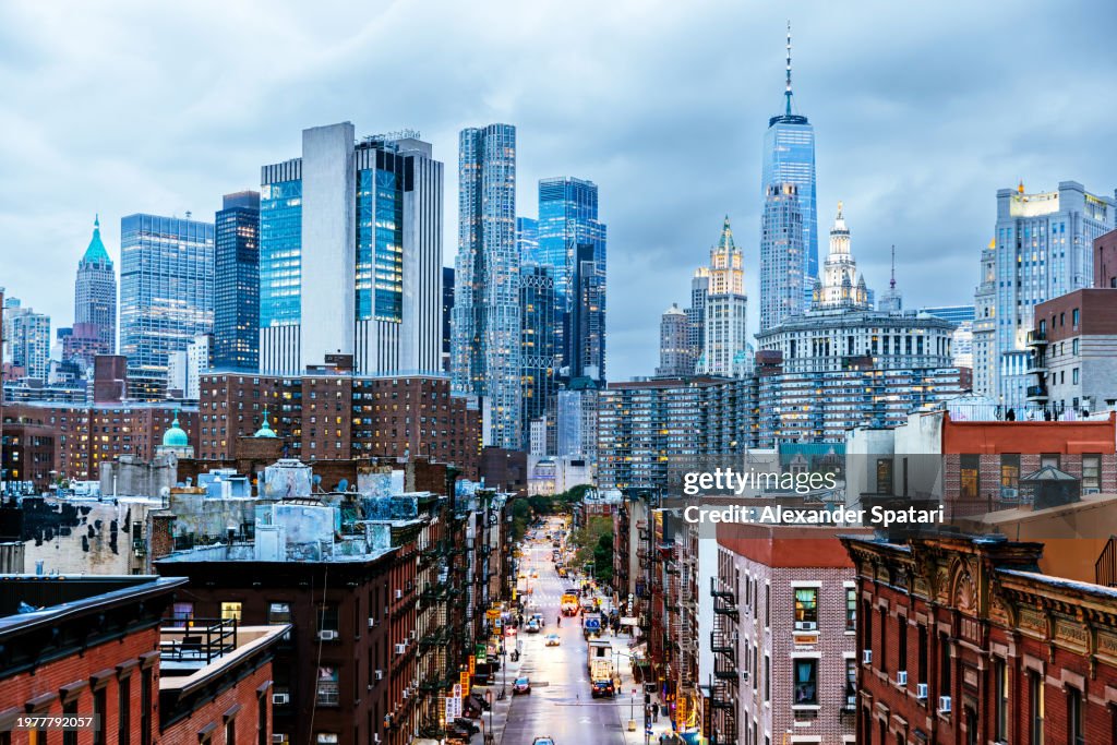 Illuminated Manhattan Financial District skyscrapers seen from Chinatown, New York City, USA