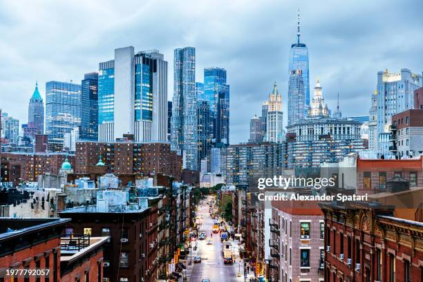 illuminated manhattan financial district skyscrapers seen from chinatown, new york city, usa - manhattan fotografías e imágenes de stock