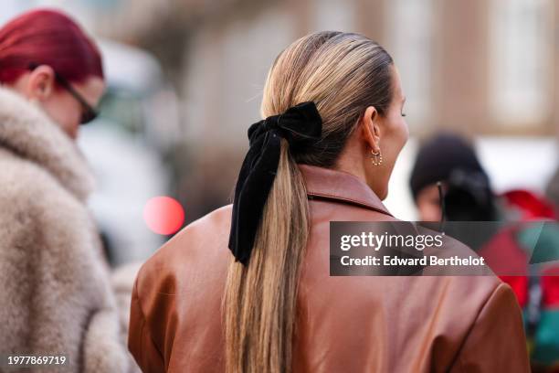 Close-up detail view of a black velvet bow hair scrunchie, and white outside The Garment, during the Copenhagen Fashion Week AW24 on January 31, 2024...