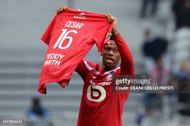 Lille's Canadian forward Jonathan David shows a jersey flocked with the firstname Cesar, a young Lille supporter, who recently died, after scoring...