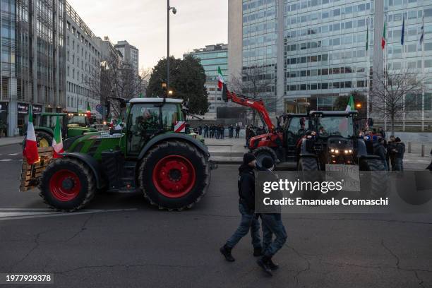 Two Police officers walk past tractors parked in front of Milan Central railway station and Grattacielo Pirelli, one of Region Lombardy's HQ, on...