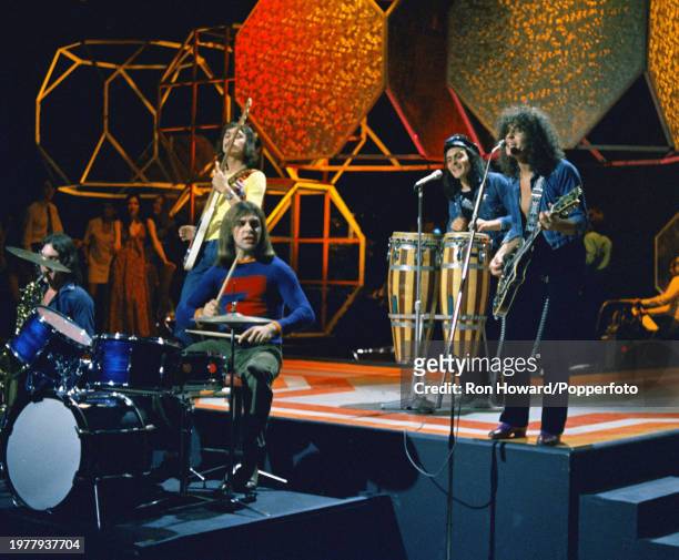 English rock band T. Rex perform in front of a studio audience on the set of a pop music television show in London circa 1970. Members of the group...