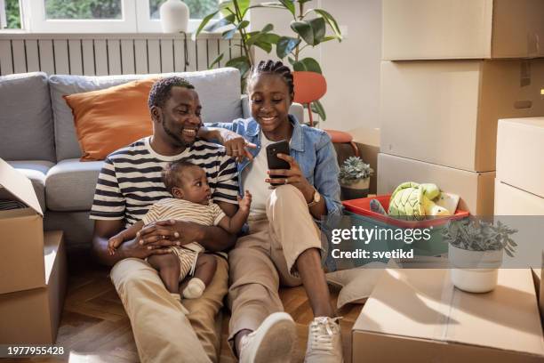 couple with baby in their new home - proprietario di casa foto e immagini stock