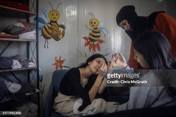 Girls living in the Buyukdalyan container camp for residents displaced by last year's earthquake learn to do make up and nail art at the camp's hair...