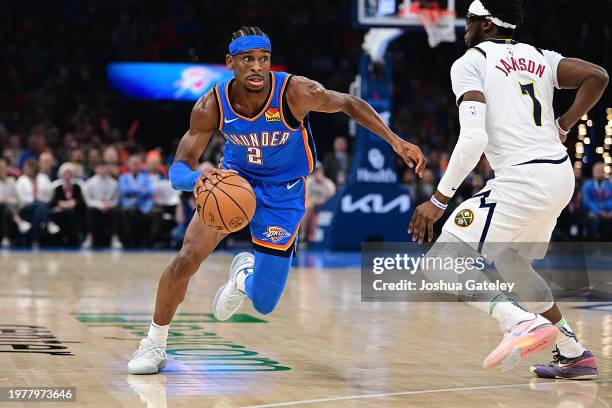 Shai Gilgeous-Alexander of the Oklahoma City Thunder attempts to drive past Reggie Jackson of the Denver Nuggets during the first half at Paycom...