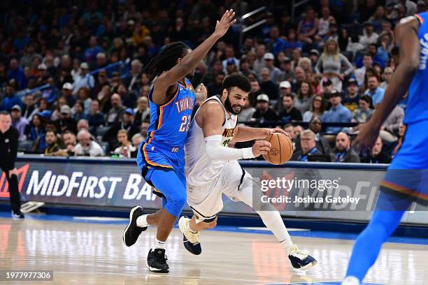 Jamal Murray of the Denver Nuggets attempts to drive past Cason Wallace of the Oklahoma City Thunder during the second half at Paycom Center on...