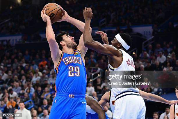 Vasilije Micic of the Oklahoma City Thunder goes up for a shot in front of Justin Holiday of the Denver Nuggets during the first half at Paycom...