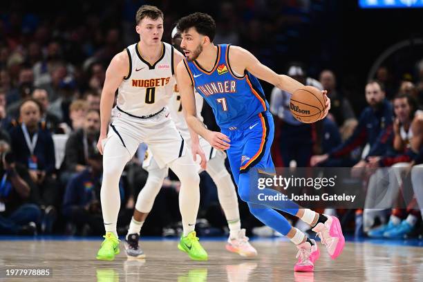 Chet Holmgren of the Oklahoma City Thunder handles the ball in front of Christian Braun of the Denver Nuggets during the second half at Paycom Center...