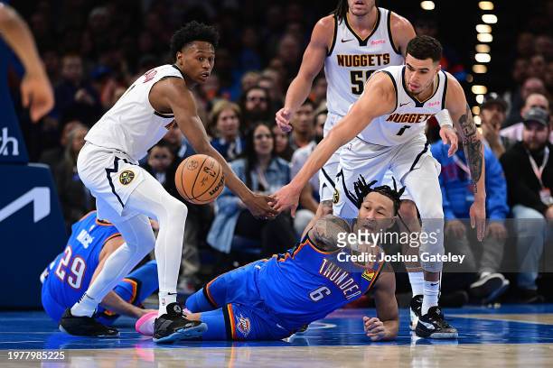 Jaylin Williams # of the Oklahoma City Thunder passes the ball away from Peyton Watson and Michael Porter Jr. #1 of the Denver Nuggets during the...