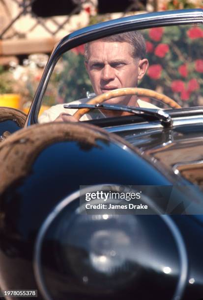 Actor and driving enthusiast Steve McQueen poses with his Jaguar XK-SS convertible at his Brentwood home in June, 1966 in Los Angeles, California.