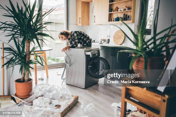 man unpacking washing machine. new washing machine. moving in a new home. - plumbing products stock pictures, royalty-free photos & images