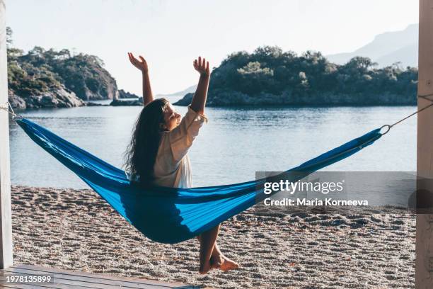 woman relaxing in a hammock on the beach. - hammock stock pictures, royalty-free photos & images